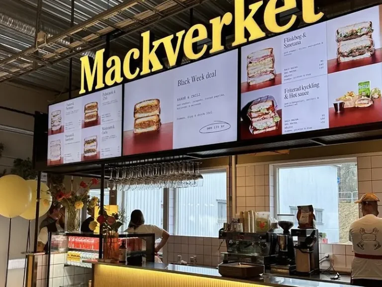 Restaurangdisk med digital meny och personal bakom kassan