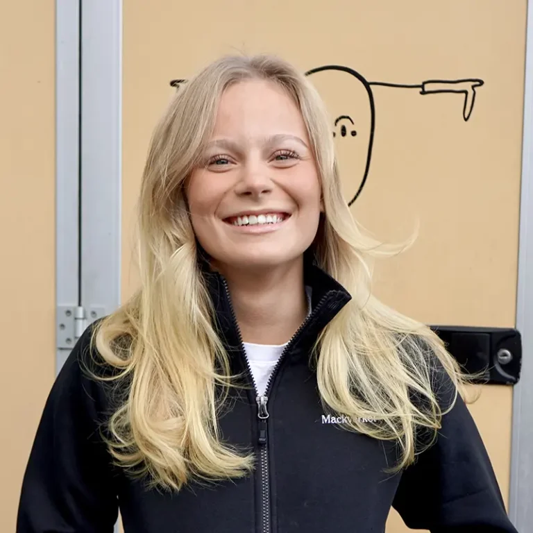 Leende Malin Lawessoni svart Mackverket-jacka framför en food truck.